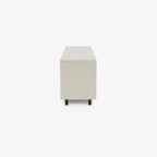 Homecrest Abbott solid wood media stand in a light neutral finish, viewed from the side with dark wooden legs.