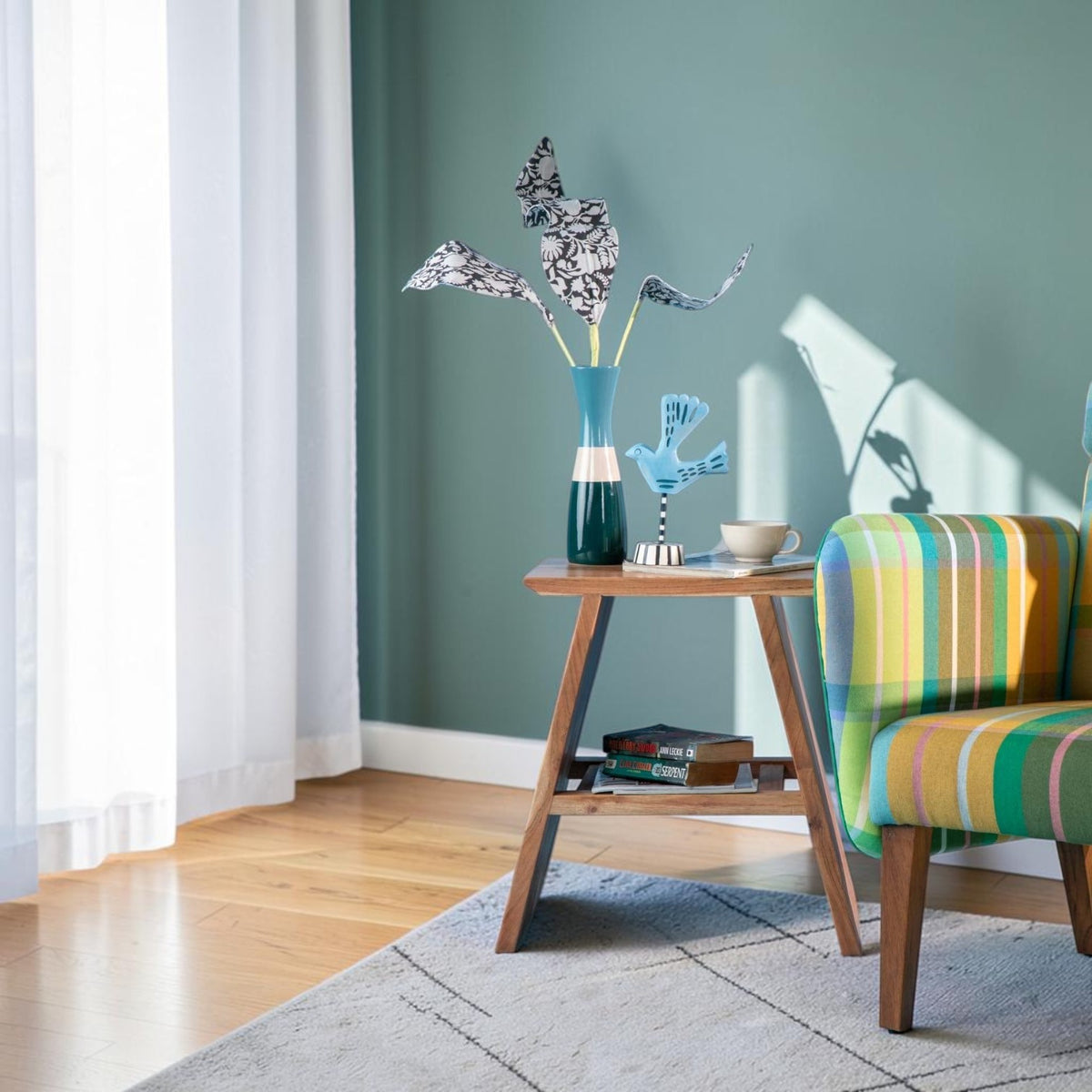 Homecrest Marlin bedside table in natural acacia wood with angular frame, styled in a coastal living room setting.