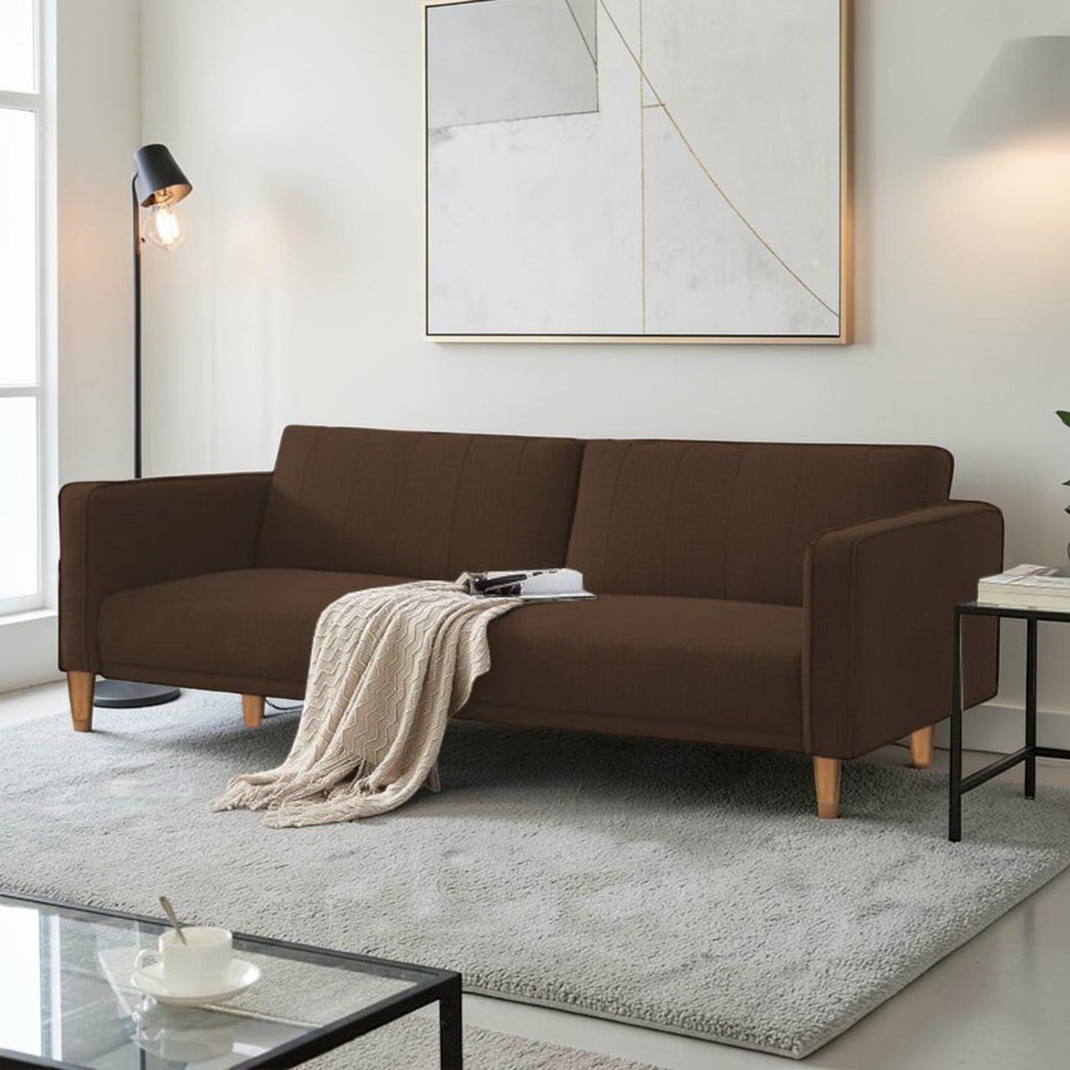 Homecrest Aldous three-seater sofa bed in brown polyester fabric with solid wood legs in a modern living room