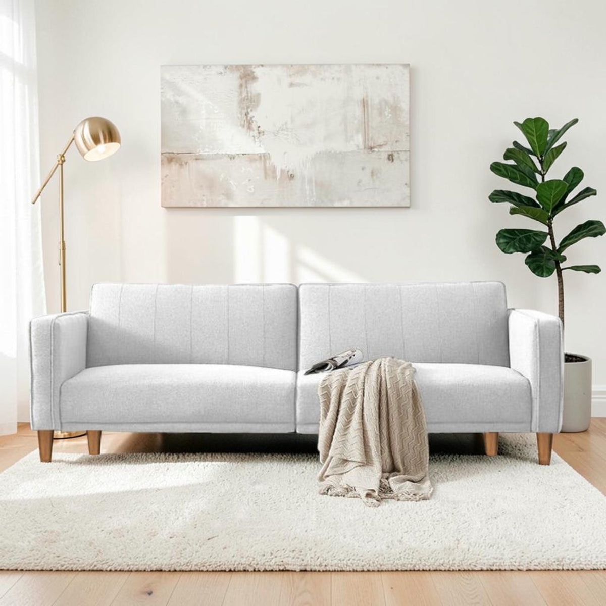 Homecrest Aldous light grey three-seater sofa bed with polyester upholstery and solid wood legs in a bright living room