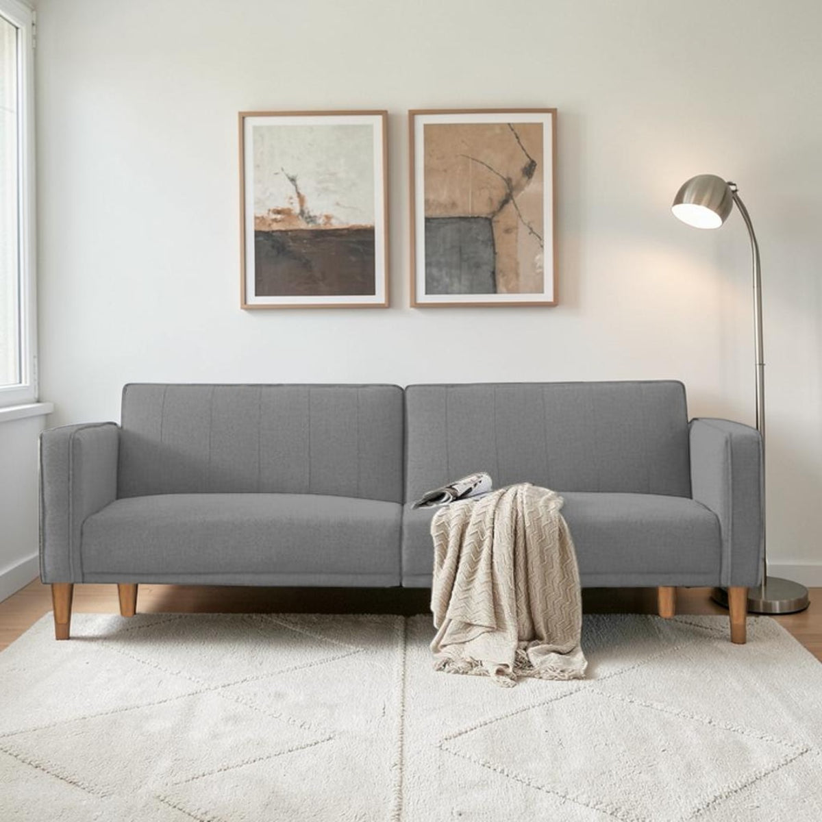 Homecrest Aldous light grey three-seater sofa bed with polyester upholstery and solid wood legs in a modern living room