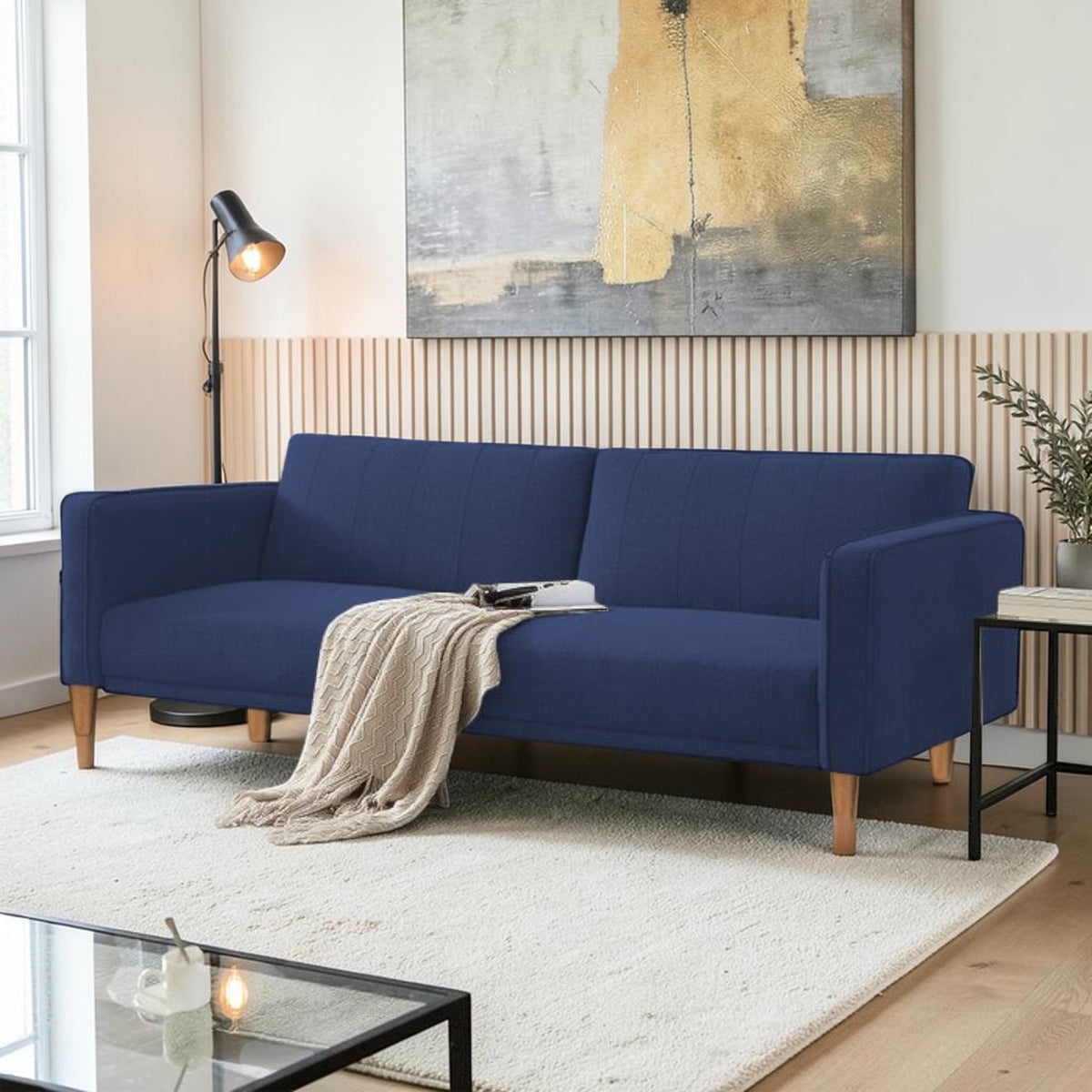 Homecrest Aldous navy blue three-seater sofa bed with polyester upholstery and solid wood legs in a modern living room