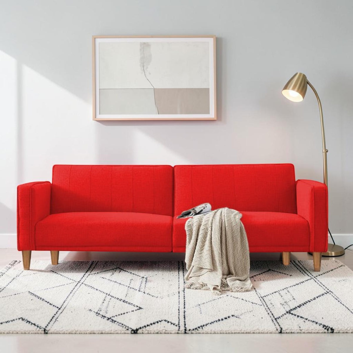 Homecrest Aldous three-seater sofa bed in vibrant red polyester fabric with solid wood legs in a modern living room