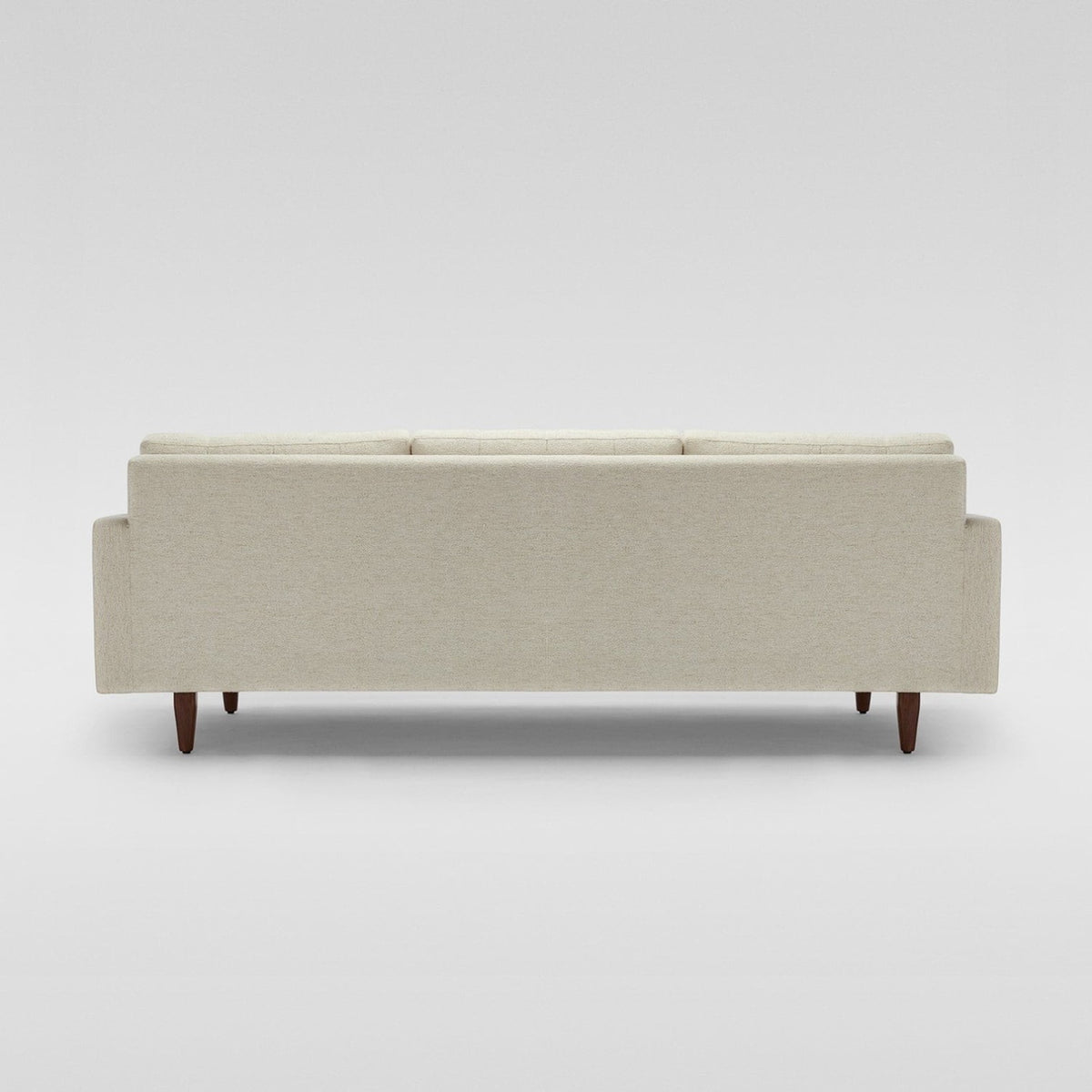 Homecrest Aldric contemporary sofa in bone fabric with slim teakwood legs, viewed from the back.