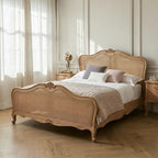 Homecrest Ancaster hand-carved natural mango wood bed with rattan detailing in a bright, elegant bedroom setting.