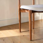 Homecrest Amberley mid-century dining chair featuring a natural teak wood frame and a neutral upholstered seat.