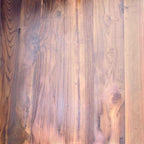 Close-up of Homecrest Anders dining table surface showing the rich grain and texture of seasoned old teak wood