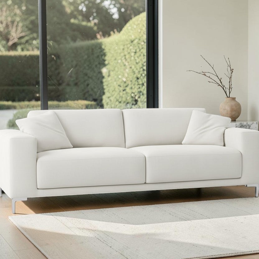 Homecrest Avebury three-seater sofa in off-white poly linen fabric with a modern minimalist design in a bright room.