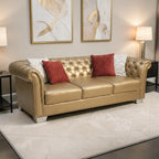 Homecrest Aurumite gold upholstered Chesterfield sofa with deep button tufting, rolled arms, and decorative pillows.