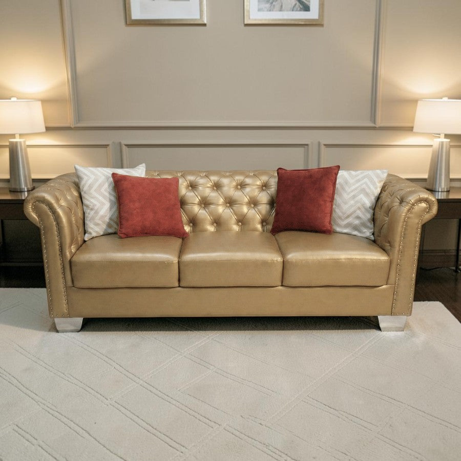 Homecrest Aurumite gold upholstered Chesterfield sofa with deep button tufting, rolled arms, and decorative pillows.