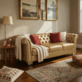 Homecrest Aurumite sofa in gold upholstery with deep button-tufting, rolled arms, and nailhead trim in a living room.
