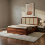 Homecrest Loreto box storage bed in rich brown Sheesham wood with a natural cane headboard in a modern bedroom.