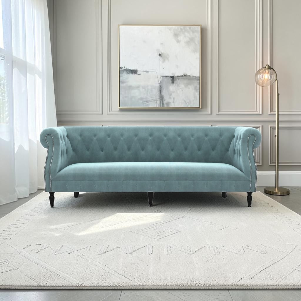 Homecrest Baslow Chesterfield sofa in dusk blue velvet with tufted backrest and nailhead trim in a modern living room.