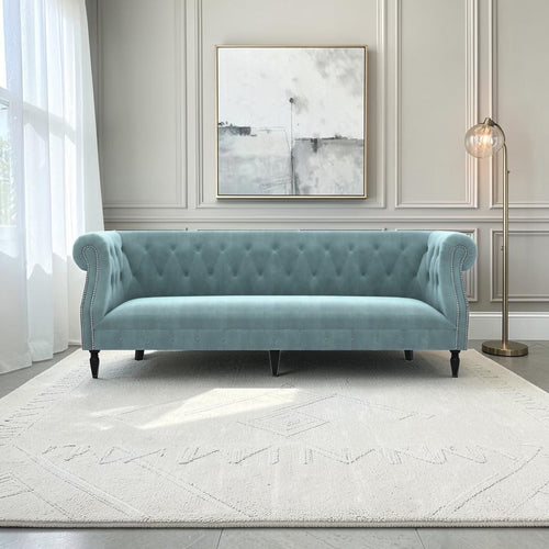 Homecrest Baslow Chesterfield sofa in dusk blue velvet with tufted backrest and nailhead trim in a modern living room.