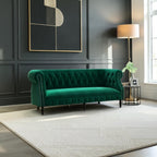Homecrest Baslow emerald green velvet Chesterfield sofa with tufted back and silver nailhead trim in a modern room.