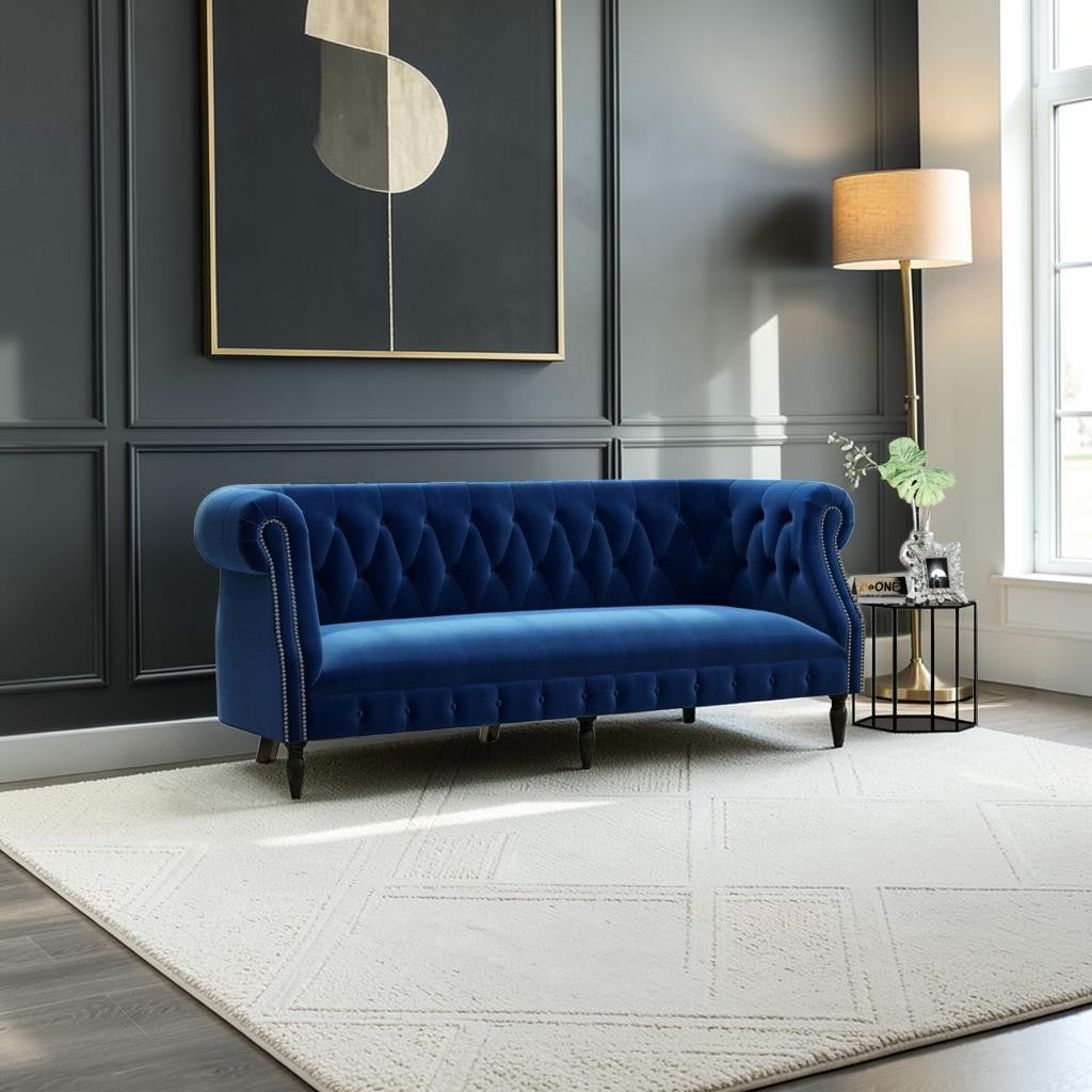Homecrest Baslow Chesterfield sofa in indigo blue velvet with button tufting and nailhead trim in a modern living room