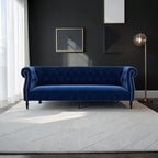 Homecrest Baslow Chesterfield sofa in indigo blue velvet with tufted back and silver nailhead trim on a white rug.