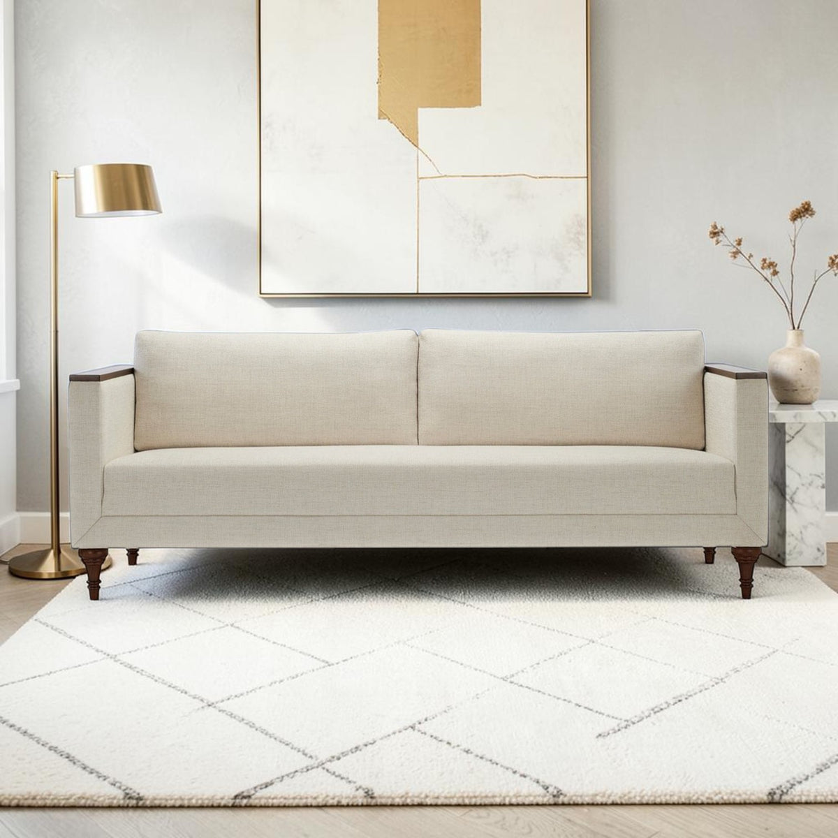 Homecrest Beaumont modern classic sofa in ivory fabric with dark wood turned legs and veneer arm wraps in a living room.