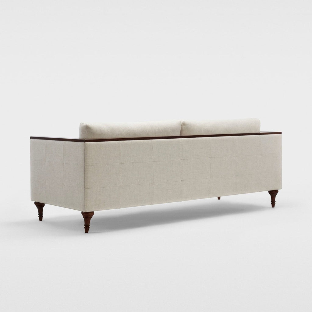 Homecrest Beaumont modern classic sofa in cream fabric with dark wood turned legs and a crisp ply-and-veneer arm wrap.