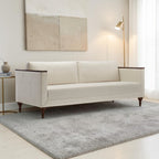 Homecrest Beaumont modern sofa in ivory fabric with dark wood arm wraps and turned teak legs in a living room.
