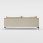 Homecrest Beaumont modern classic sofa in ivory fabric with a squared frame and dark turned teakwood legs, back view.