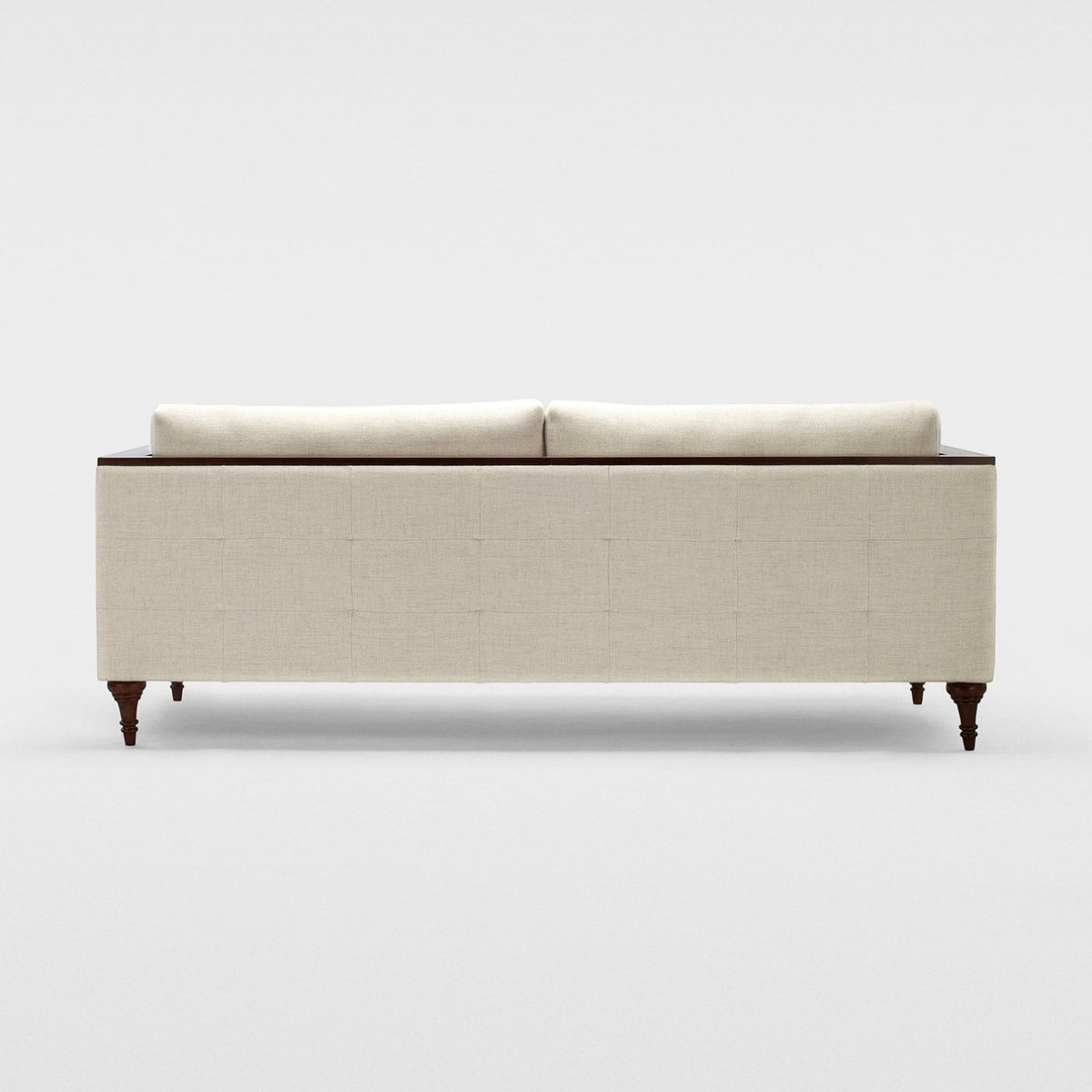 Homecrest Beaumont modern classic sofa in ivory fabric with a squared frame and dark turned teakwood legs, back view.
