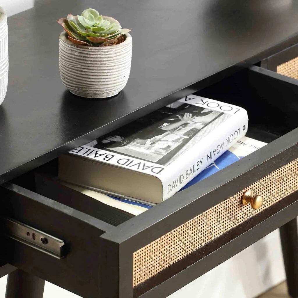 Homecrest black console table with an open drawer featuring woven rattan cane front and a small gold handle