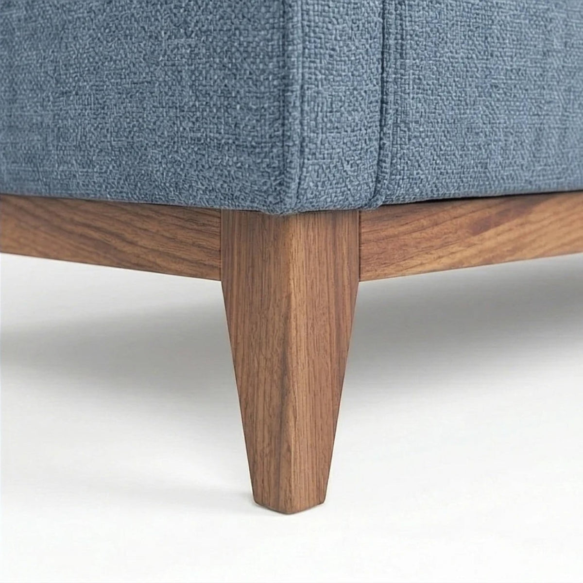 Homecrest 3-seater sofa featuring blue fabric upholstery and a natural solid wood base with tapered legs