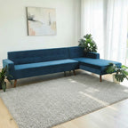 Homecrest mid-century blue velvet button-down sectional sofa with teak wood legs in a bright living room