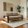 Homecrest Bramshaw 3-seater sofa with solid wood frame, natural cane side panels, and beige fabric cushions in a room.