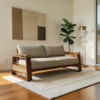 Homecrest Bramshaw 3-seater sofa with solid wood frame, natural cane side panels, and beige fabric cushions in a room.