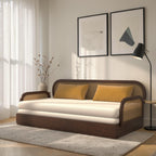 Homecrest Brayton acacia wood daybed with rounded cane-panel back and side rests, featuring cream cushions and pillows.