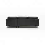 Homecrest Camber sectional sofa in rhino black leather with a deep boxy silhouette and dark wooden legs, back view.