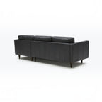 Homecrest Camber sectional sofa in rhino black leather with a boxy silhouette and tapered wooden legs, back view.