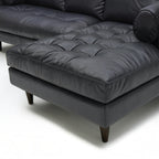 Homecrest Camber sectional sofa in rhino black leather with button-tufted seating and solid wood legs.