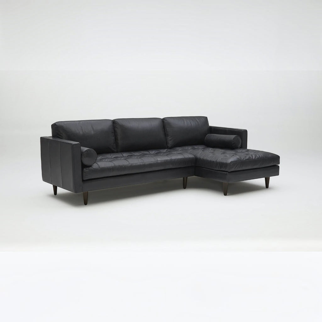 Homecrest Camber sectional sofa in rhino black leather with button-tufted seating and a deep boxy silhouette.