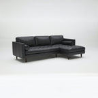 Homecrest Camber sectional sofa in rhino black leather with button-tufted seating and a deep boxy silhouette.