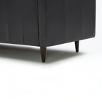 Homecrest Camber sectional sofa in rhino black leather with tapered dark wood legs on a white background