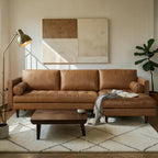 Homecrest Camber camel brown leather sectional sofa with button-tufted seating and solid wood frame in a living room.