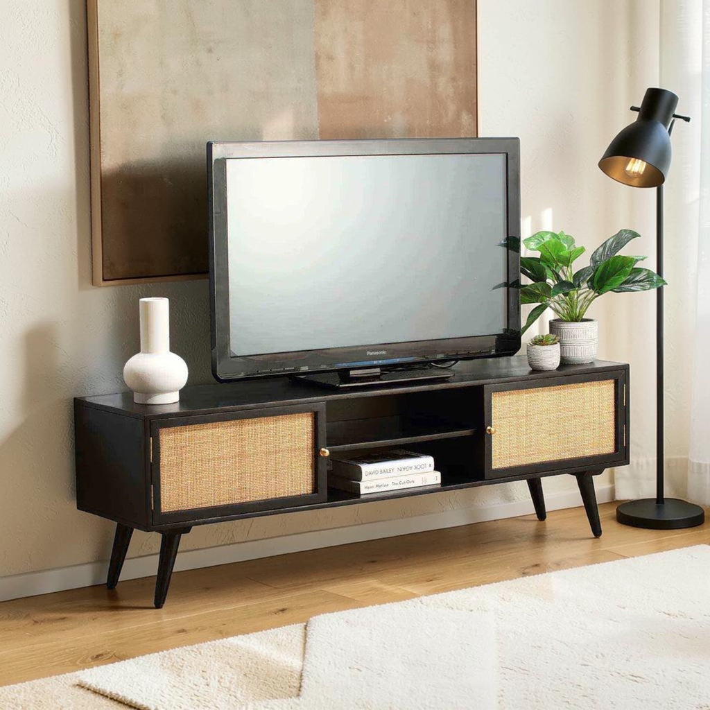 Homecrest Calder black media cabinet with rattan doors, gold handles, and open shelves in a modern living room