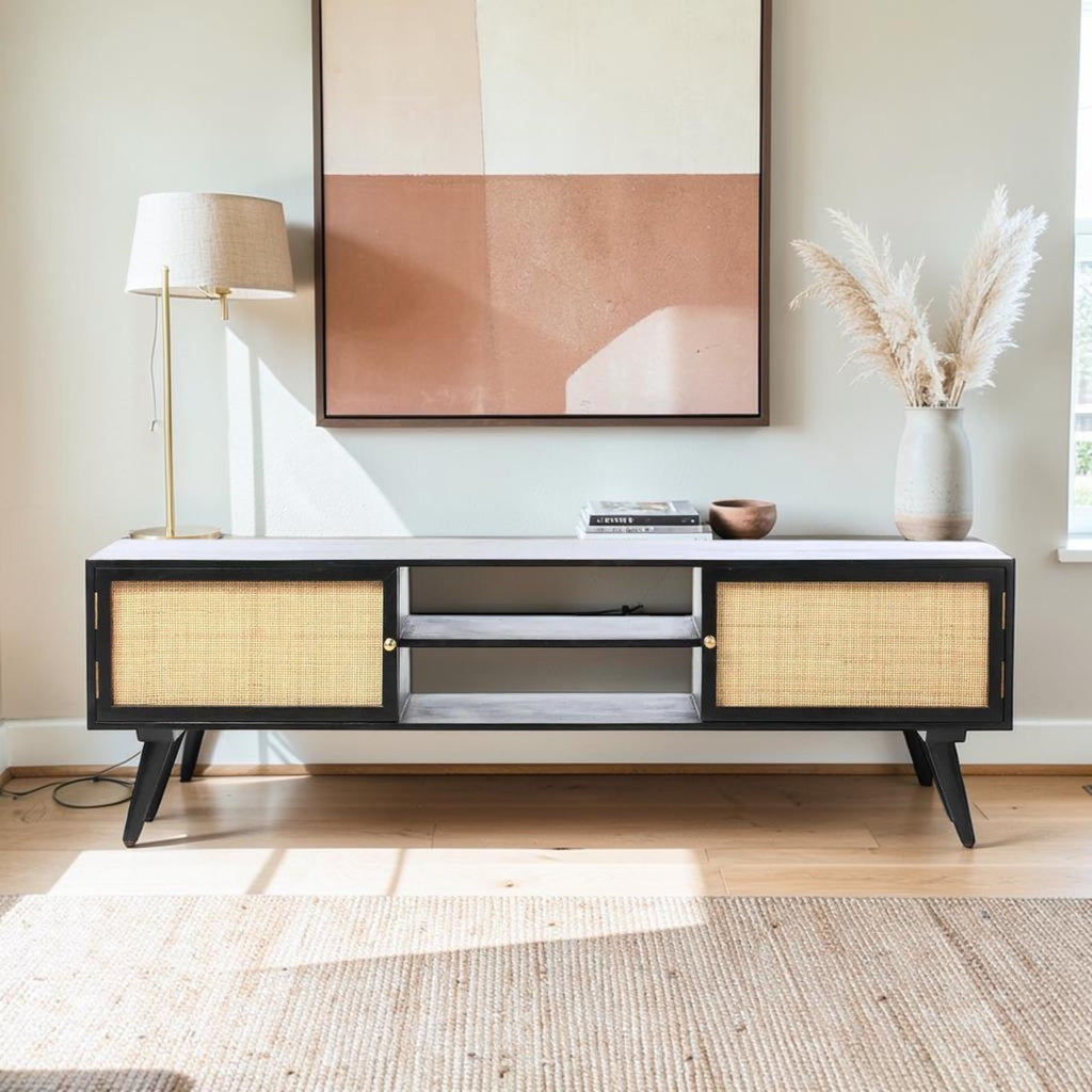Homecrest Calder black media cabinet with rattan doors, gold handles, and open shelving in a bright living room.