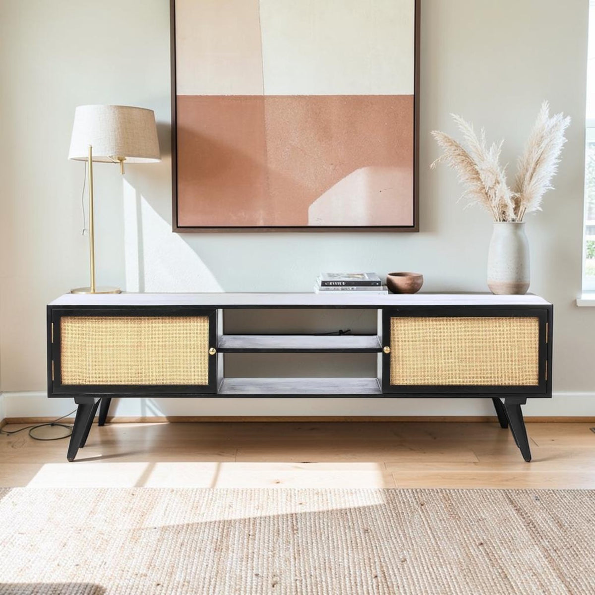 Homecrest Calder black media cabinet with rattan doors, gold handles, and open shelving in a bright living room.