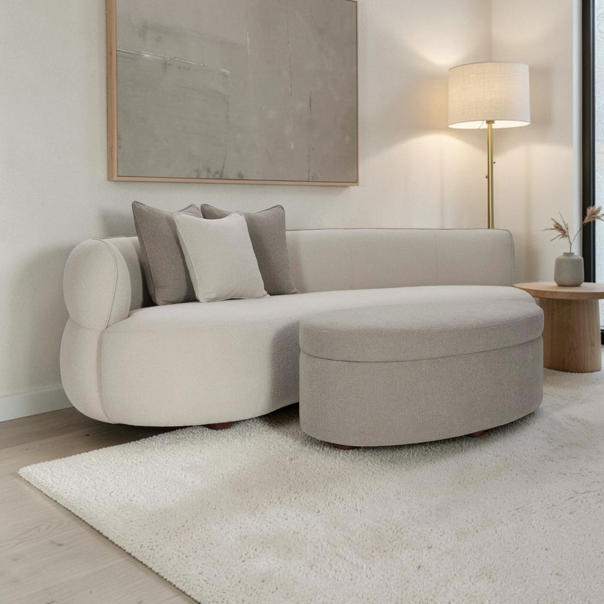 Homecrest Calla curved bean-shaped sofa in two-tone boucle fabric with matching ottoman and teakwood legs in a living room.