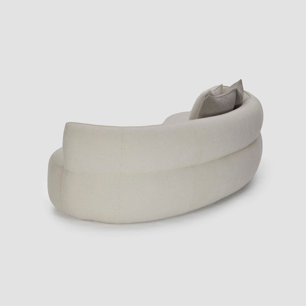 Homecrest Calla curved bean-form sofa in cream boucle fabric with a low-profile sweeping silhouette and back cushions.