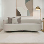 Homecrest Calla curved bean-form sofa in two-tone boucle fabric with teakwood legs and decorative throw cushions.
