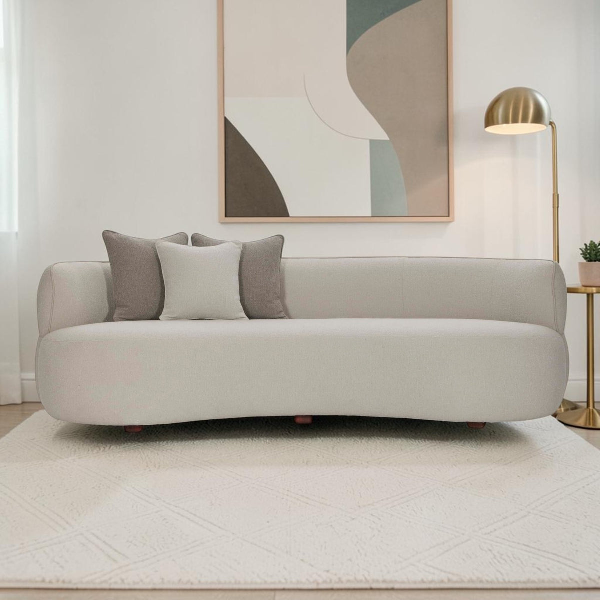 Homecrest Calla curved bean-form sofa in two-tone boucle fabric with teakwood legs and decorative throw cushions.