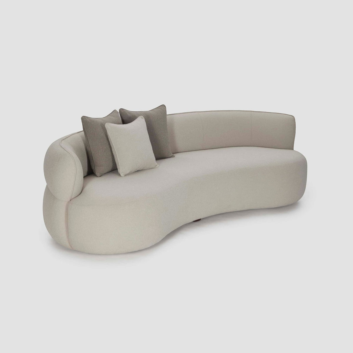 Homecrest Calla curved bean-shaped sofa in cream boucle fabric with two-tone accent cushions and teakwood legs.