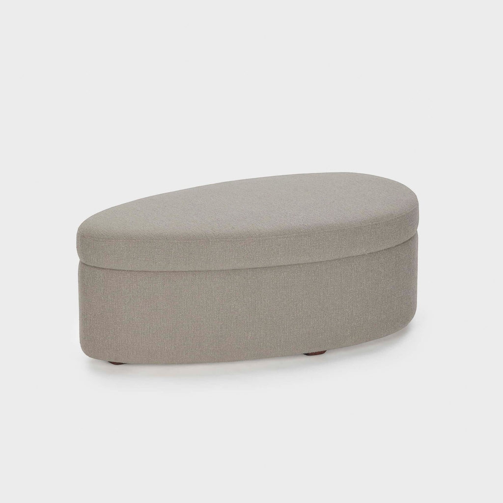 Homecrest Calla bean-shaped ottoman in grey boucle fabric with a low profile and rounded edges on a white background.