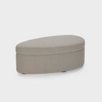 Homecrest Calla bean-shaped ottoman in grey boucle fabric with a low profile and rounded edges on a white background.