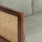 Homecrest 2-seater sofa with walnut wood frame, woven cane side panels, and sage green fabric upholstered cushions.